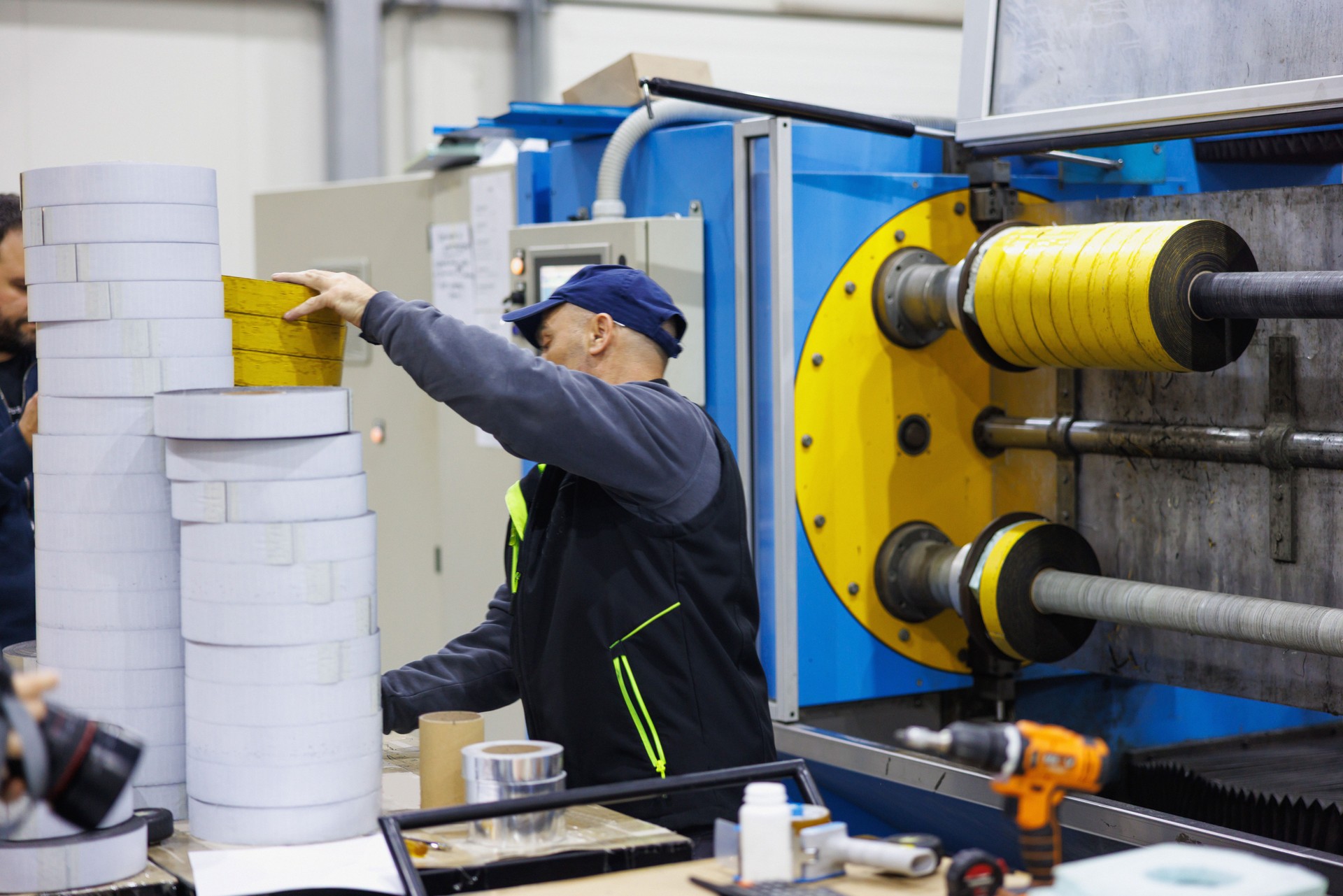 Man working in production line, electrical insulating tape on the machine spools